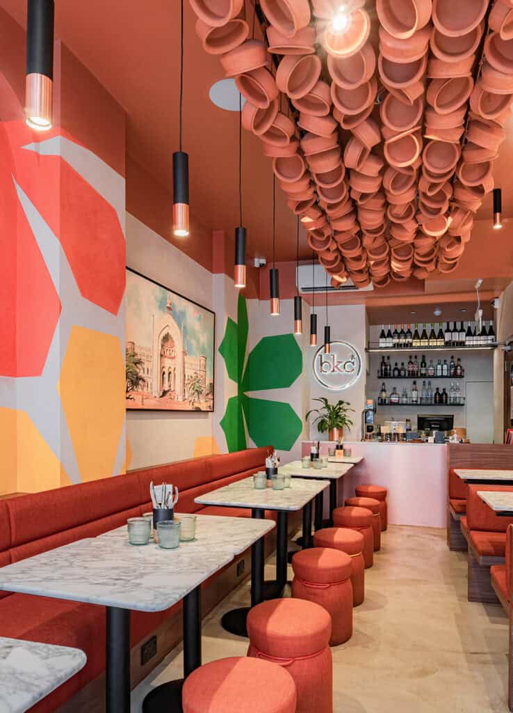 Modern cafe interior with vibrant wall art and unique ceiling decor.